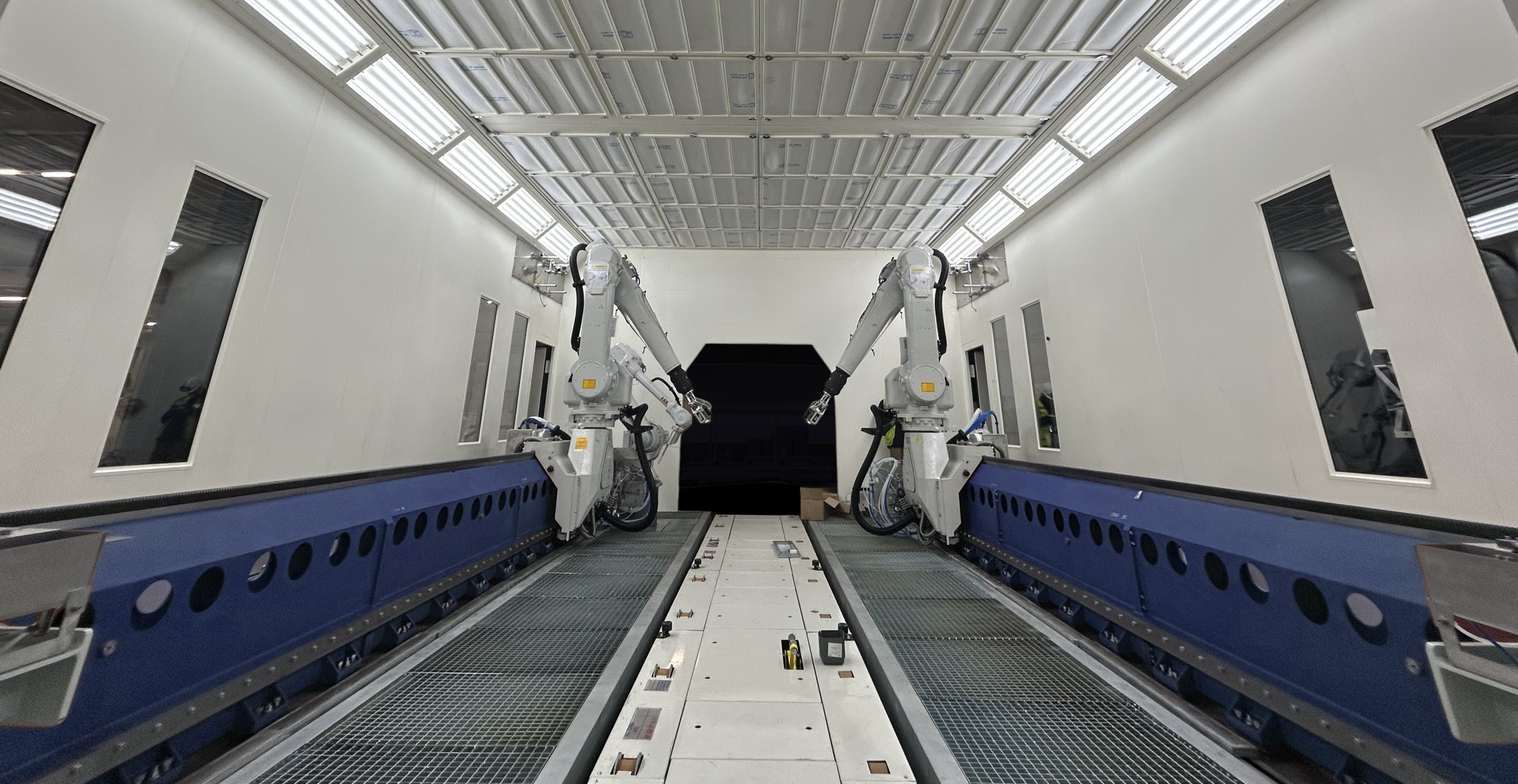 Réalisations EPI Europe Cabine OFA avec bras automatiques sur ligne de peinture industrielle.