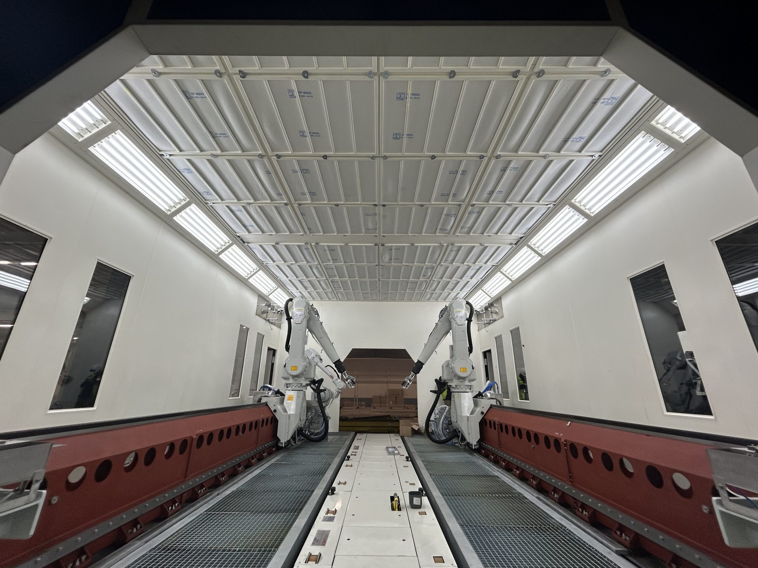 Réalisations EPI Europe Cabine OFA avec bras automatiques sur ligne de peinture industrielle.